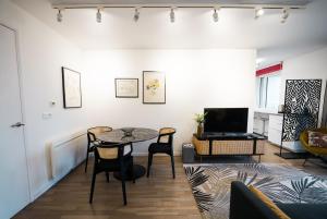 a living room with a table and chairs and a television at Sky One La Defense in Courbevoie