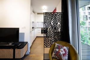a living room with a chair and a table and a kitchen at Sky One La Defense in Courbevoie +15 photos
