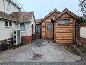 a house with a wooden garage in a driveway at Oak framed appartment in Chester