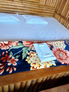a bed with a book on a floral bedspread at Meghh Minar Homestay Sillery Gaon in Kalimpong +17 photos