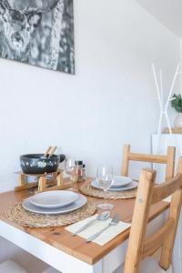 a dining room table with plates and wine glasses at Le Tracouet - Central et cosy studio in Nendaz +13 photos