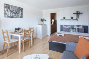 a bedroom with a bed and a table and a kitchen at Le Tracouet - Central et cosy studio in Nendaz