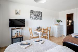 a room with a bed and a table and a television at Le Tracouet - Central et cosy studio in Nendaz