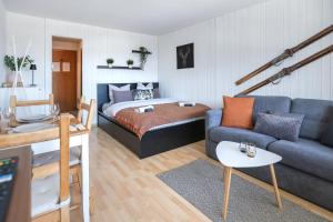 a living room with a bed and a couch at Le Tracouet - Central et cosy studio in Nendaz