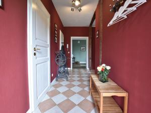 a hallway with red walls and a table with flowers on it at Historic Apartment in Gerdshagen with Garden in Gerdshagen