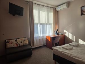 a bedroom with a bed and a desk and a window at "Hel" Wieniec Zdrój in Włocławek