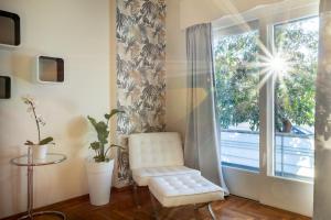 a white chair sitting in front of a window at Elegant Garden Apartment Walk to Kalamata Center 2BR in Kalamata
