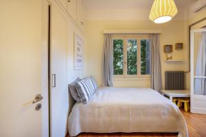 a bedroom with a bed and a window at Elegant Garden Apartment Walk to Kalamata Center 2BR in Kalamata