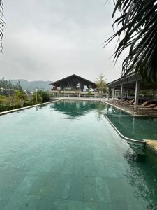 a large pool of green water with a building at Khu Nghỉ Dưỡng Ivory Villa Resort in Lương Sơn