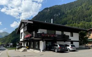 a building with two cars parked in a parking lot at K-Appartements Klösterle in Klösterle