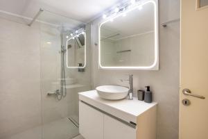 a white bathroom with a sink and a shower at Elegant Garden Apartment Walk to Kalamata Center 2BR in Kalamata