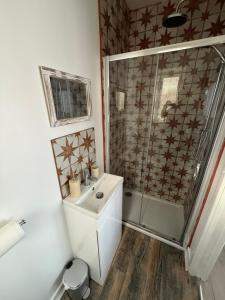 a white bathroom with a sink and a shower at Starfish Snug in Brixham