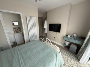 a bedroom with a bed and a desk and a television at Starfish Snug in Brixham