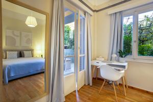 a bedroom with a bed and a desk and a window at Elegant Garden Apartment Walk to Kalamata Center 2BR in Kalamata +78 photos
