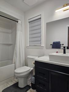 ein weißes Badezimmer mit Toilette und Waschbecken in der Unterkunft Elegant 3-bedroom Home Away From Home, Luxury Styled in St. John's