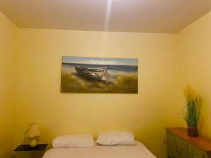 a bedroom with a painting of a boat on the wall at Babo Bolton room en suite in Farnworth +3 photos