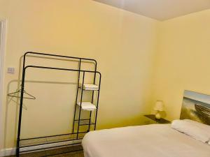 a room with a bed and a towel rack at Babo Bolton room en suite in Farnworth