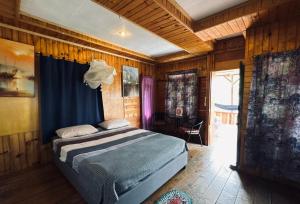 a bedroom with a bed in a room with wooden walls at Hot Chilli Hotel in Tuktuk Siadong