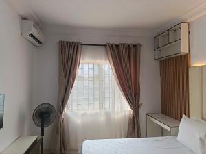 a bedroom with a bed and a window at Kbazz apartments in Ibadan