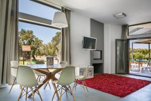 a dining room with a table and chairs and a large window at Villa Katrin in Svoronata
