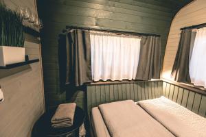 ein kleines Zimmer mit einem Bett und einem Fenster in der Unterkunft Lakeside Sunset in Alūksne