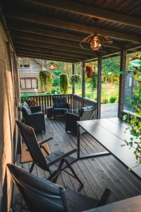 eine Terrasse mit Tisch und Stühlen auf einem Deck in der Unterkunft Lakeside Sunset in Alūksne