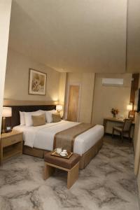 a hotel room with a large bed and a table at Hotel & Resto Marza 88 in Pangkajene +2 photos