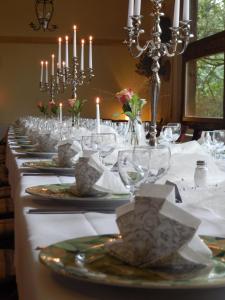a long table with plates and glasses and candles at Hotel Alte Försterei in Jüterbog +71 photos