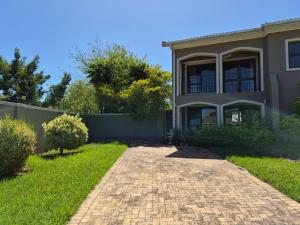 a house with a brick driveway in front of it at Somerset Garden Studio in Somerset West
