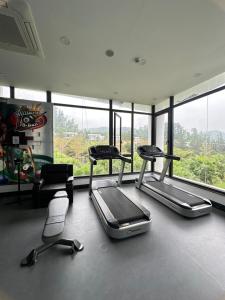 a gym with three cardio machines in front of a window at Khu Nghỉ Dưỡng Ivory Villa Resort in Lương Sơn