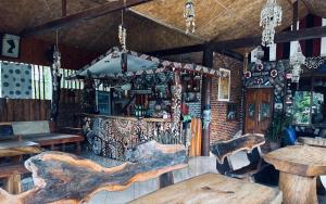 a bar with wooden tables and chairs in a room at Hot Chilli Hotel in Tuktuk Siadong