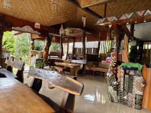 a restaurant with wooden tables and benches in a room at Hot Chilli Hotel in Tuktuk Siadong