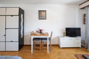 a small dining room with a table and a television at Le Cleuson - centré avec vue in Nendaz