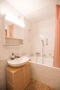 a bathroom with a sink and a bath tub at Le Cleuson - centré avec vue in Nendaz +14 photos