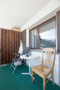 a room with a table and a chair and a window at Le Cleuson - centré avec vue in Nendaz