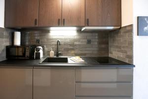 a kitchen with a sink and a microwave at Le Cleuson - centré avec vue in Nendaz