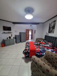 a living room with two beds and a couch at Villa Caramia Guest Lodge in Jan Kempdorp
