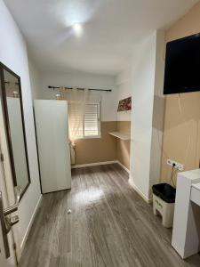 an empty room with a white door and a television at Avenue Rooms in Valencia