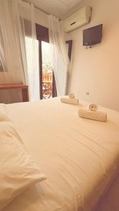 a bedroom with a white bed with towels on it at Kỳma - Stone Luxury Villa in Órmos Koumaíïkon