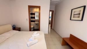 a hotel room with a bed with towels on it at Kỳma - Stone Luxury Villa in Órmos Koumaíïkon
