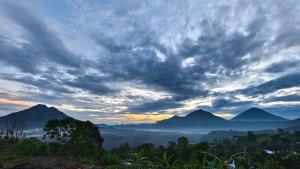 a cloudy sky with mountains in the background at Arkaluna Resort & Adventure in Kintamani