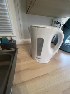 a white coffee cup sitting on a kitchen floor at Mobil-home 1 in Quimper