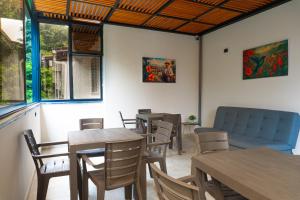 a restaurant with tables and chairs and a couch at NOVA Apartahotel in Medellín