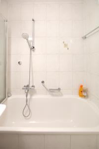 a white bath tub with a shower in a bathroom at Nendaz Olympic Ski-In Ski-Out in Nendaz +24 photos