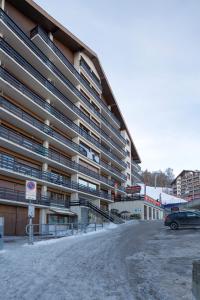 a large building with a car parked in front of it at Nendaz Olympic Ski-In Ski-Out in Nendaz