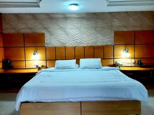 a bedroom with a large white bed with two lamps at Hotel Presidente Asunción in Asunción +45 photos