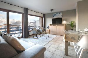 a living room with a couch and a table with chairs at Nendaz Olympic Ski-In Ski-Out in Nendaz