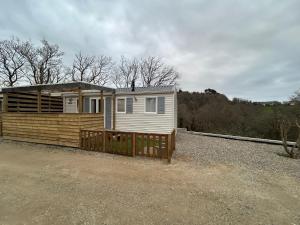 a small house with a wooden fence in front of it at Mobil-home 1 in Quimper