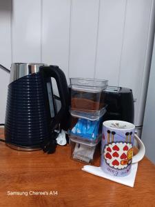 a counter with a toaster and a cup on a table at The Flat 28B on Ordnance in Lithgow +3 photos