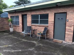 a building with two chairs and a table in front of it at The Flat 28B on Ordnance in Lithgow